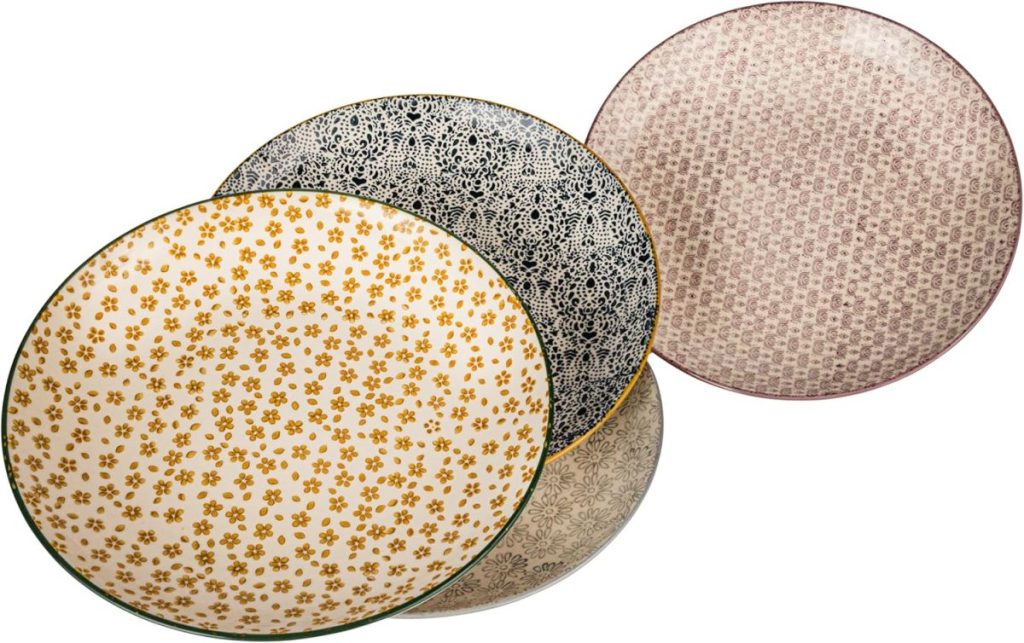 Four round plates with different intricate patterns and colors, including yellow floral, black and white, beige, and pink designs, arranged overlapping each other—perfect for serving dishes like Marry Me Chicken at your next gathering.