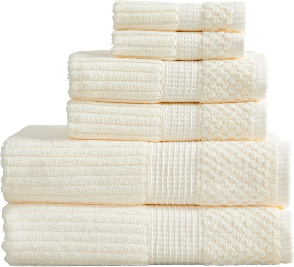 A neatly stacked set of cream-colored towels in various sizes and textures, arranged in descending order from bottom to top&mdash;perfect for adding a touch of Airbnb-style comfort to your Waco home.