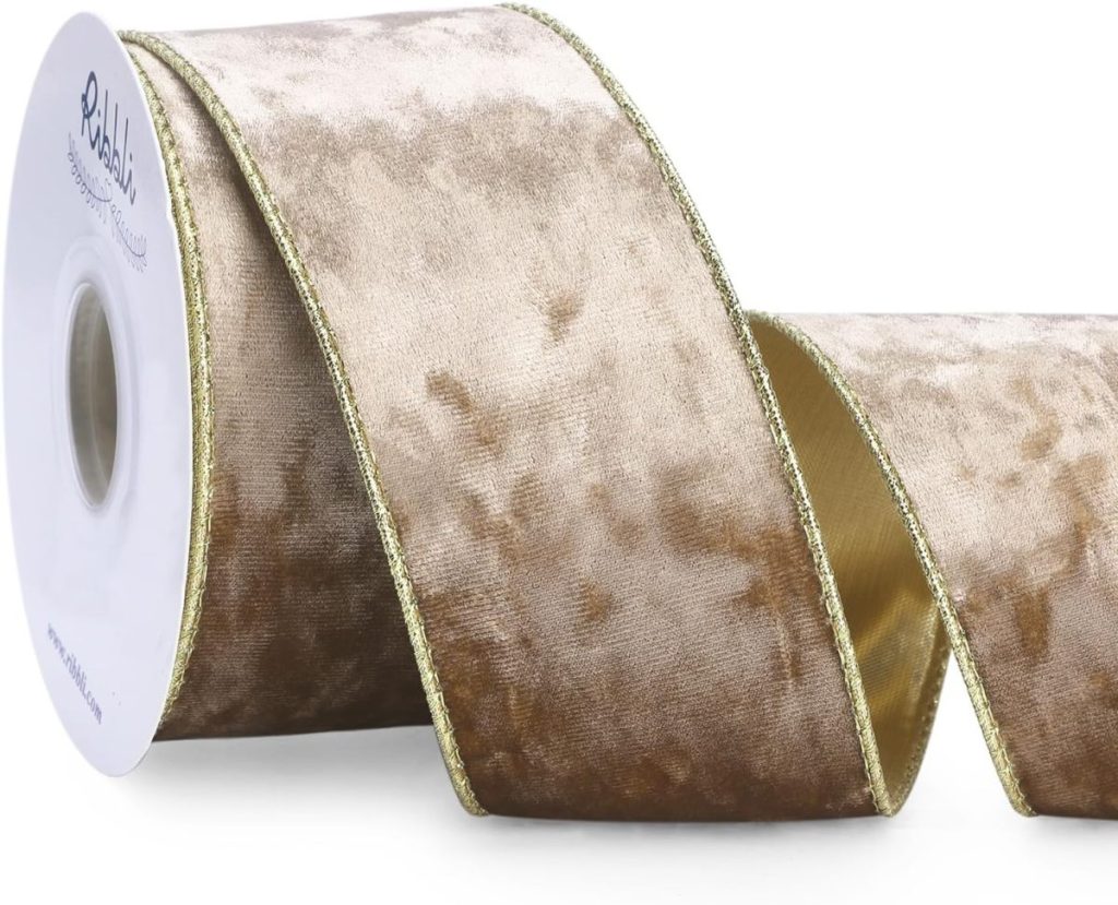 A roll of wide, velvet ribbon in a beige and brown marbled pattern with gold metallic edging, partially unspooled.