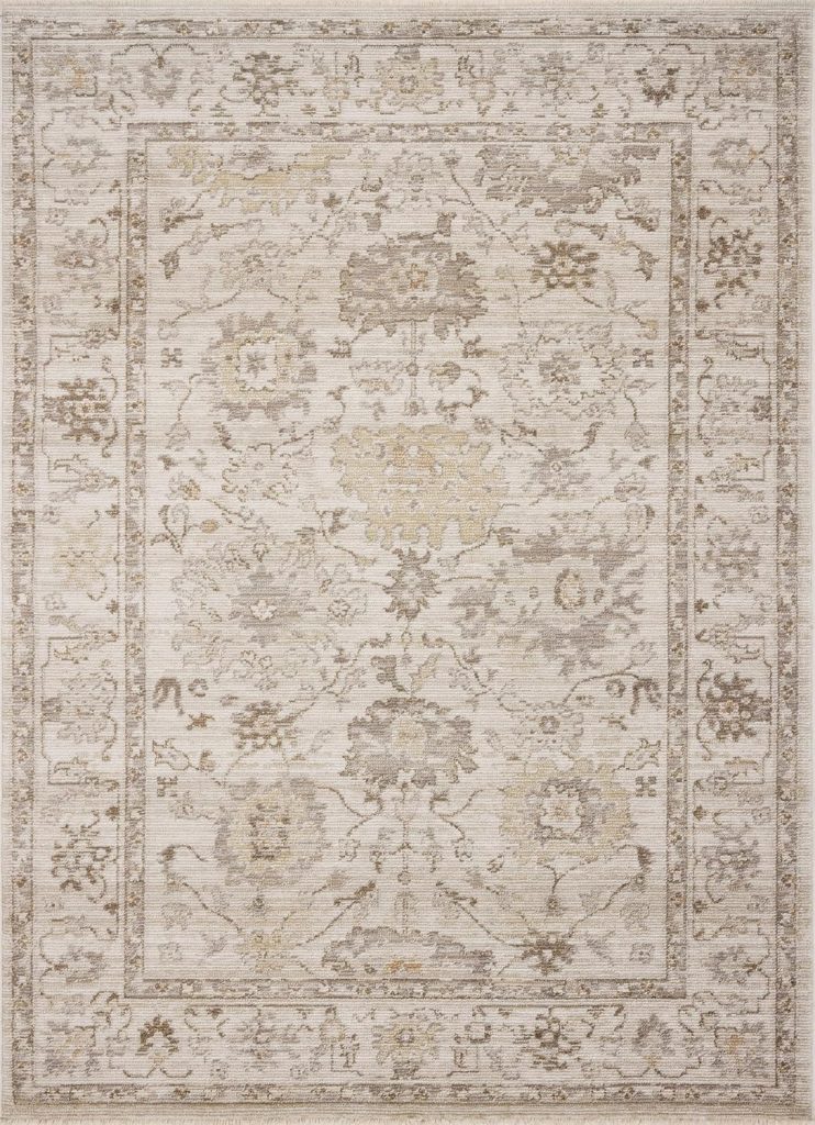 A rectangular area rug with a light beige background and an ornate floral and vine pattern in muted gray and gold tones, bordered by a matching decorative frame—perfect for refreshing your space during Amazon Prime Big Deal Days.