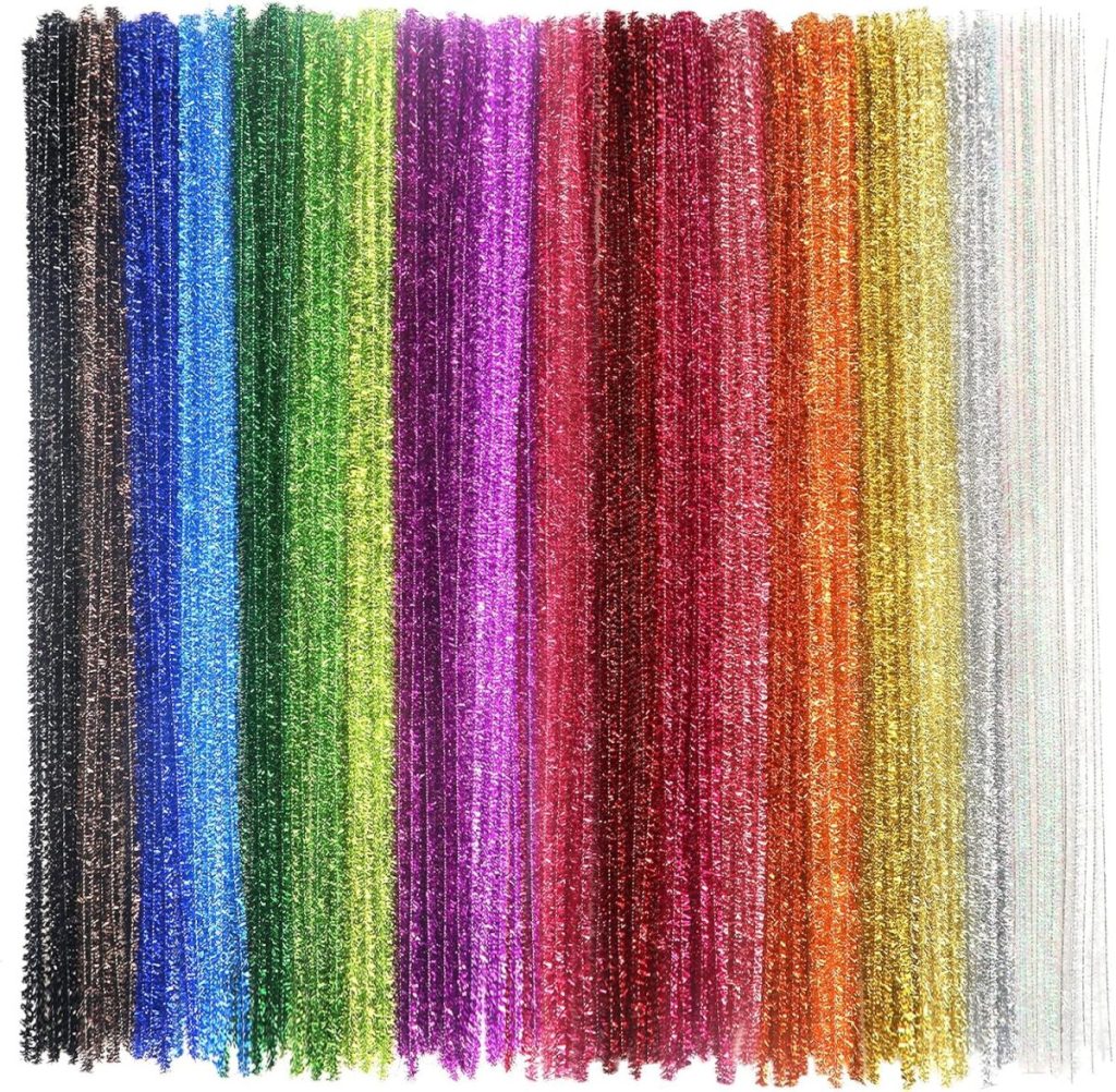 A set of colorful, sparkly pipe cleaners arranged vertically in parallel rows, resembling miniature Glitter Christmas Trees in a variety of bright colors including blue, green, purple, red, gold, and silver.