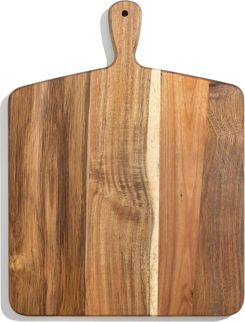 A rectangular wooden cutting board with a handle, showing natural wood grain and color variations.