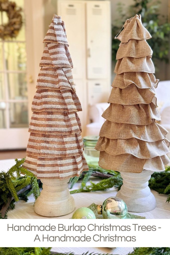 Two handmade burlap Christmas trees with ruffled layers stand on white bases, surrounded by greenery and ornaments indoors.