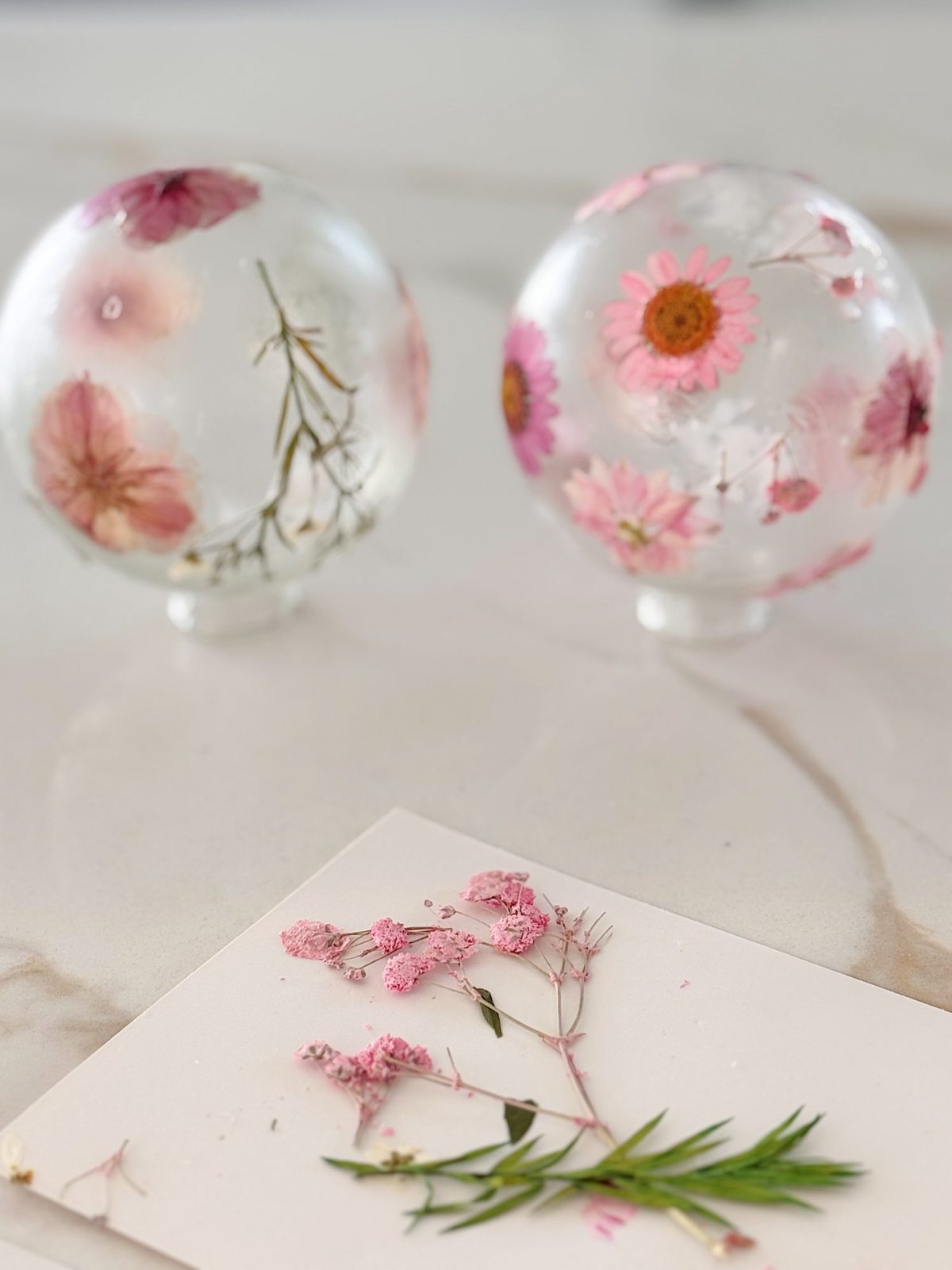 Two glass balls with flowers on them.