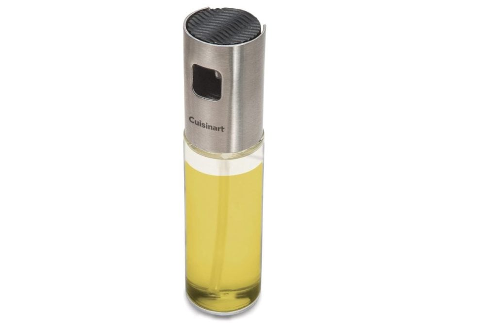A glass oil mister with a stainless steel top labeled "Cuisinart," containing yellow cooking oil—perfect for adding a touch of flavor to your dishes, especially during special moments like Christmas Morning.