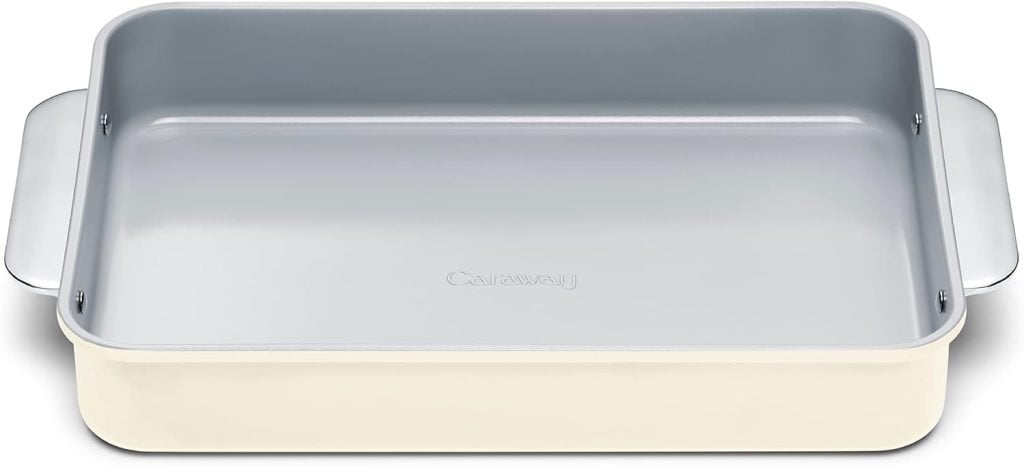 Rectangular, cream-colored baking dish with light gray nonstick interior and handles on each side, viewed from above. The word "Caraway" is embossed on the interior base.