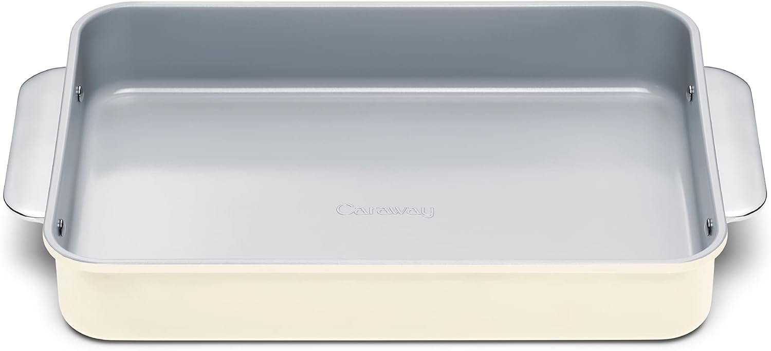 Rectangular, cream-colored baking dish with light gray nonstick interior and handles on each side, viewed from above. The word "Caraway" is embossed on the interior base.