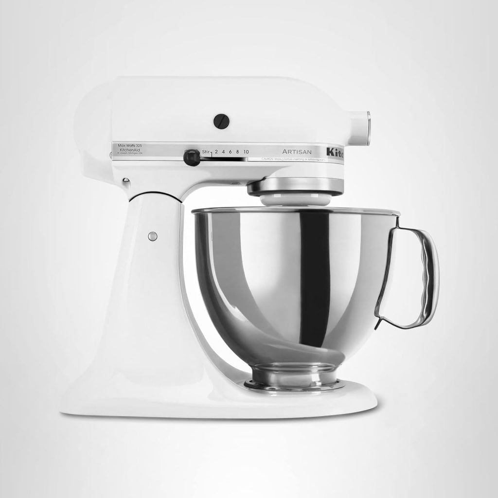 A white stand mixer with a stainless steel mixing bowl attached, photographed against a plain light gray background.