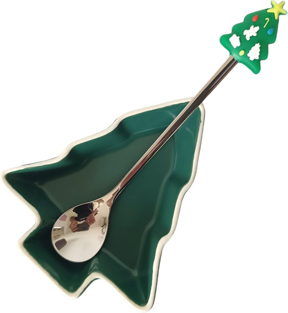 A green, tree-shaped dish with a metal spoon featuring a Christmas tree decoration on the handle.