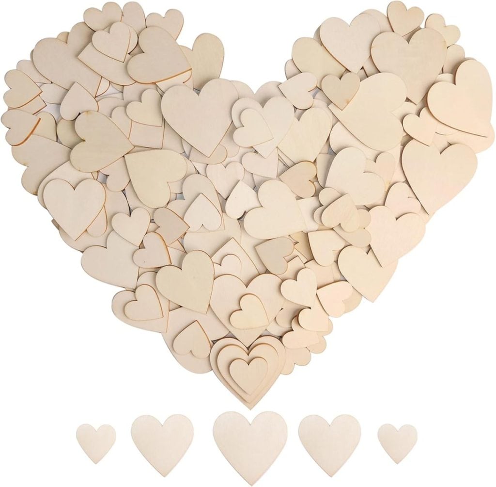 A large heart shape made from many small, light-colored wooden heart cutouts, with five additional wooden hearts arranged below.