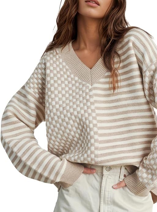 A woman wears a beige and white checkered and striped sweater with cream-colored high-waisted shorts, posing with hands in pockets—perfect for your Black Friday style inspiration.