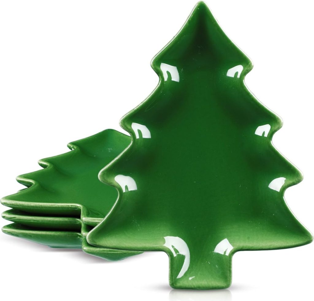 A stack of four green ceramic plates shaped like Christmas trees, with the top plate standing upright and the rest stacked behind.