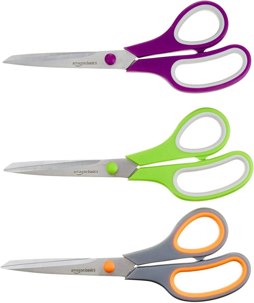 Three pairs of Amazon Basics scissors with stainless steel blades—perfect for window art projects—feature plastic handles in purple, green, and gray with orange accents, arranged horizontally on a white background.