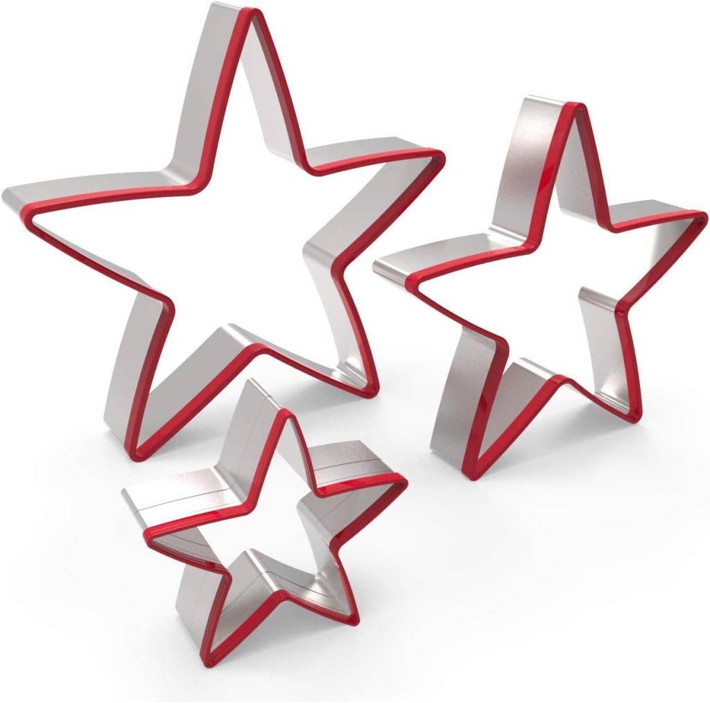 Three metal star-shaped cookie cutters with red edges, arranged upright on a white background in varying sizes.