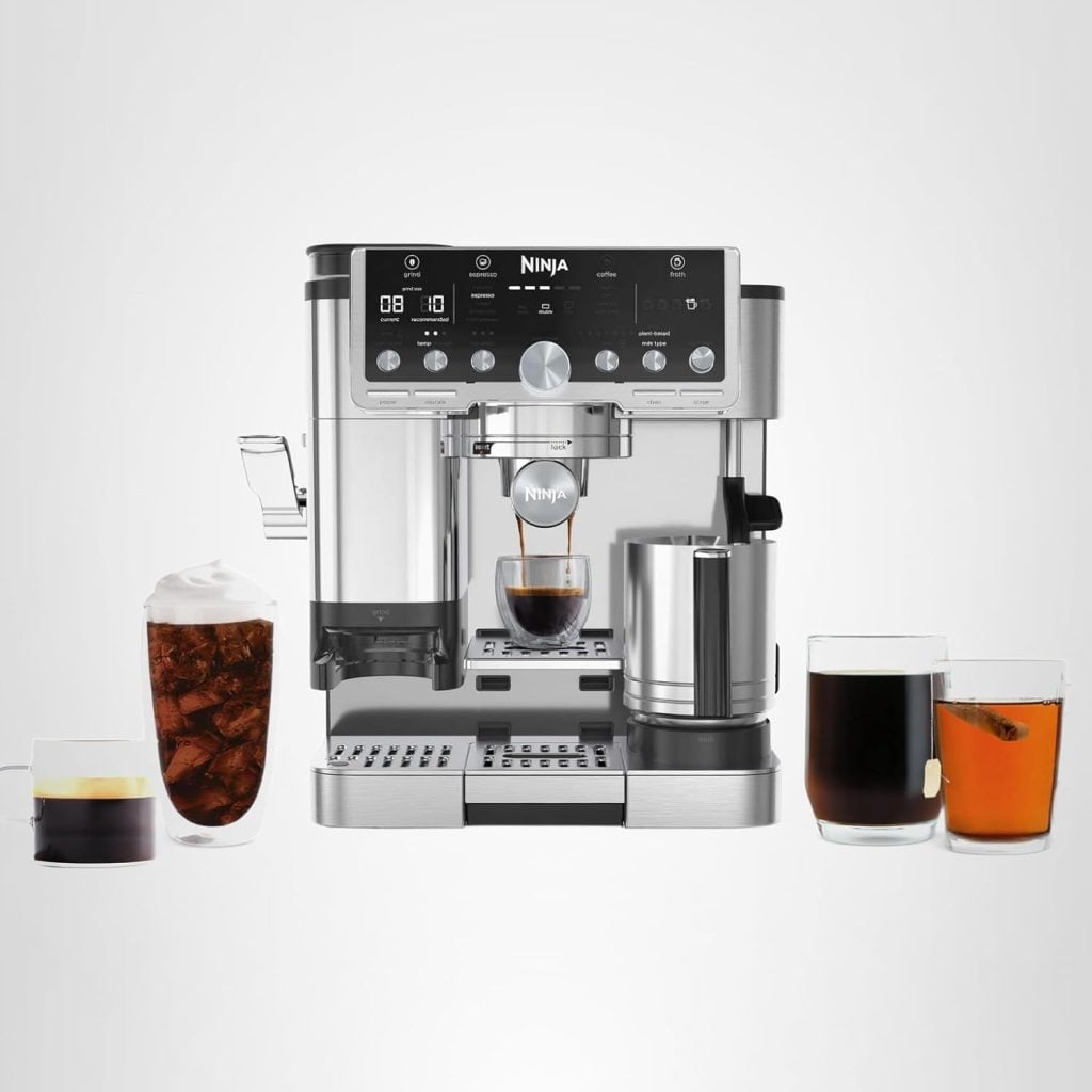 A Ninja espresso and coffee barista system brewing espresso, with four different coffee drinks placed around the machine on a white background.