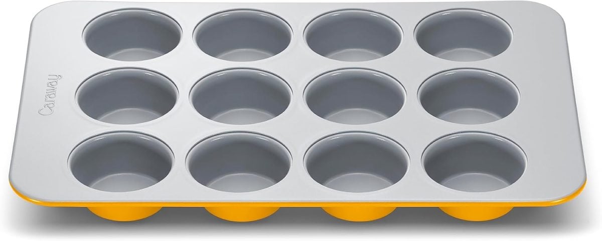 A 12-cup muffin pan with a gray nonstick interior and a yellow base, shown from an overhead angle&mdash;perfect for baking treats to feature in blog posts.