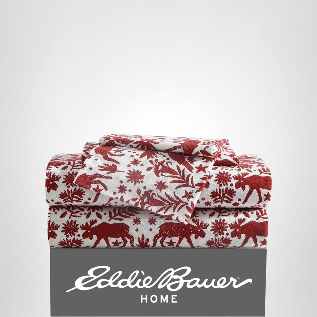 Folded red and white sheet set with a nature and moose pattern, placed on a box labeled "Eddie Bauer Home.