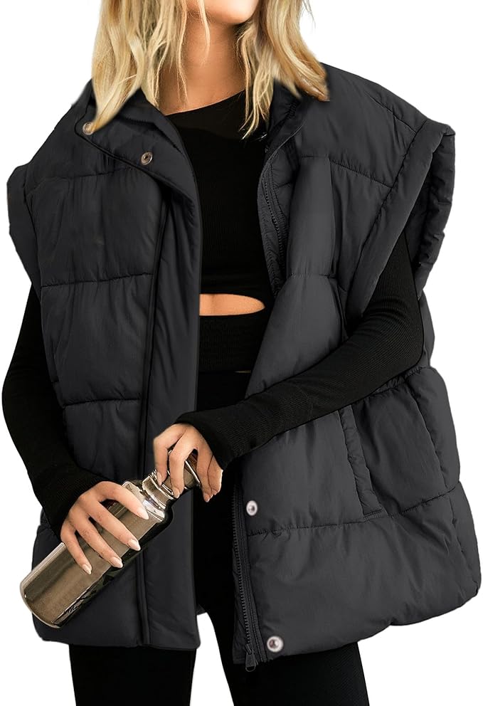 Person wearing a black puffer vest over a black long-sleeve top with a cutout, holding a stainless steel water bottle.