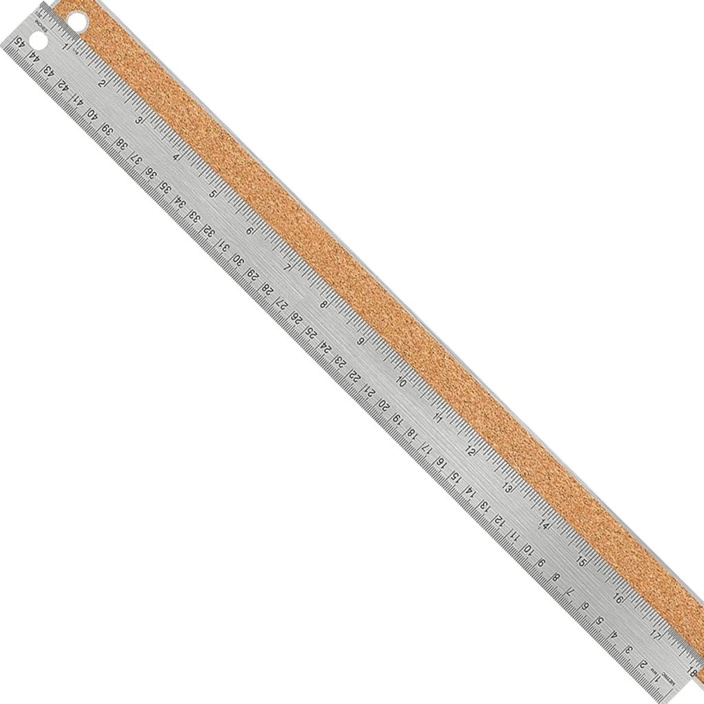 A metal ruler with metric and imperial measurements, featuring a cork backing and a hole at one end for hanging.