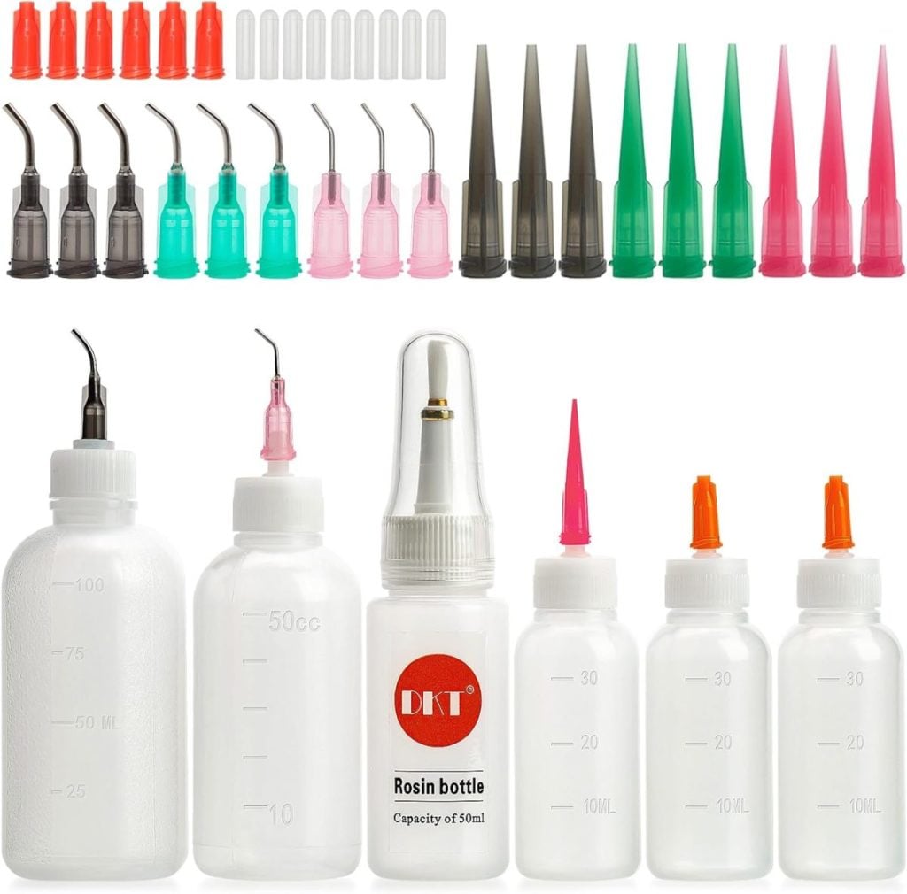 Various plastic squeeze bottles with measuring marks and an assortment of colored needle tip applicator caps and covers are arranged in rows.
