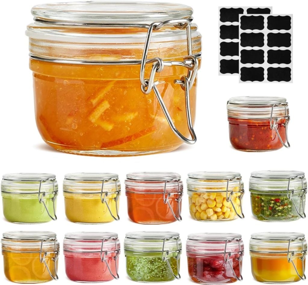 A set of twelve glass jars with hinged lids, each filled with different foods or sauces, shown with black label stickers in the background.