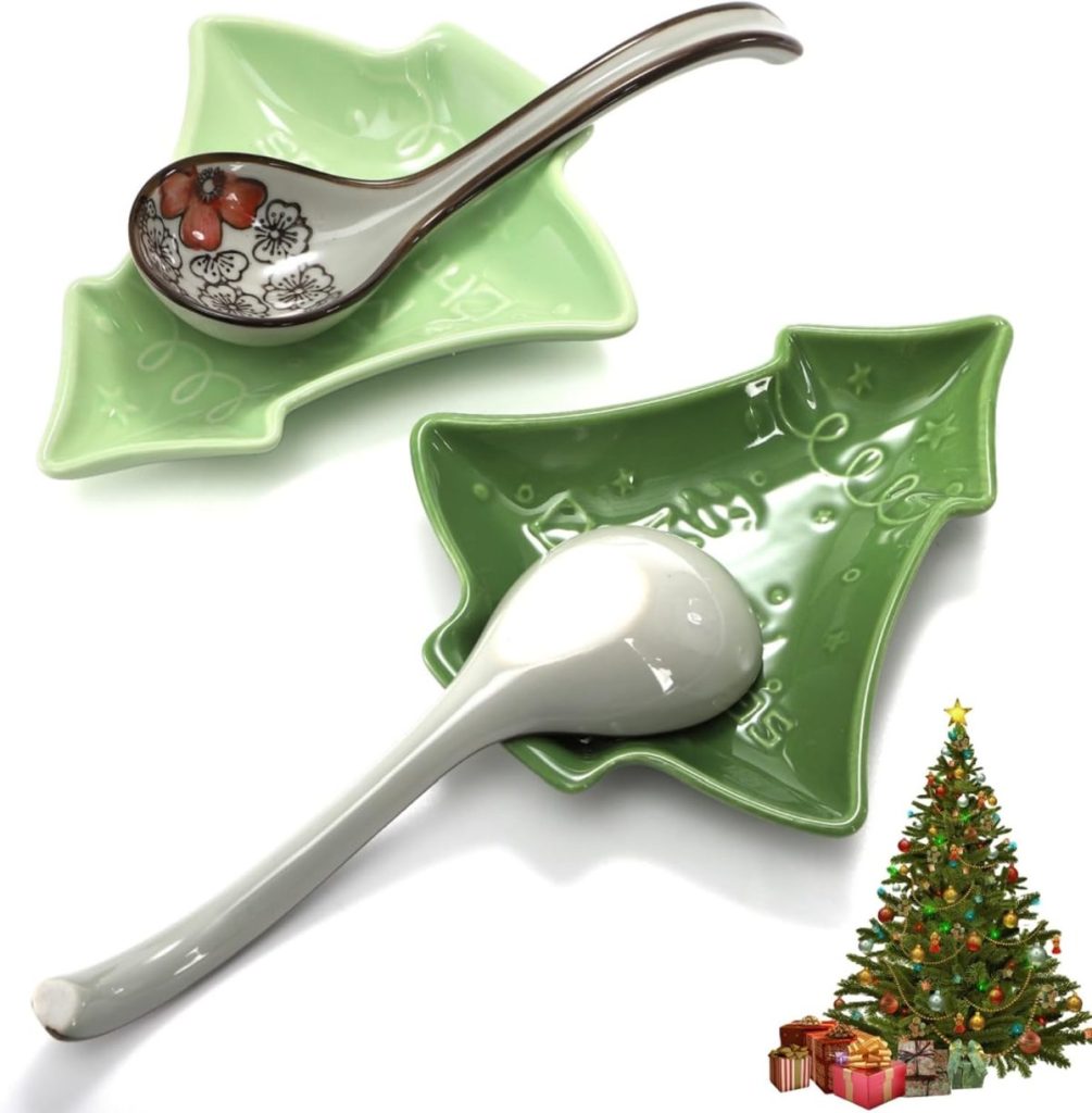 Two ceramic soup spoons rest in green, Christmas tree-shaped dishes. A decorated Christmas tree with presents is in the bottom right corner.