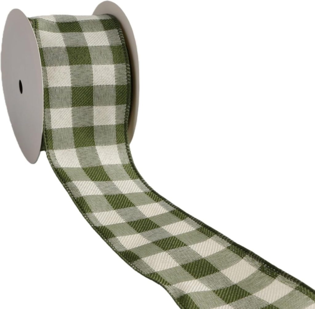 A spool of ribbon with a green and white plaid pattern, partially unrolled on a white background.