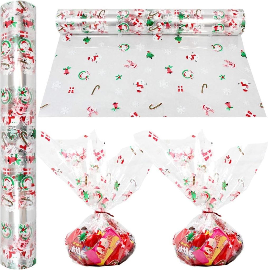 Clear Christmas-themed cellophane wrap with Santa, snowflakes, and candy designs, shown as a roll, unrolled sheet, and wrapped around gift bags of candy.
