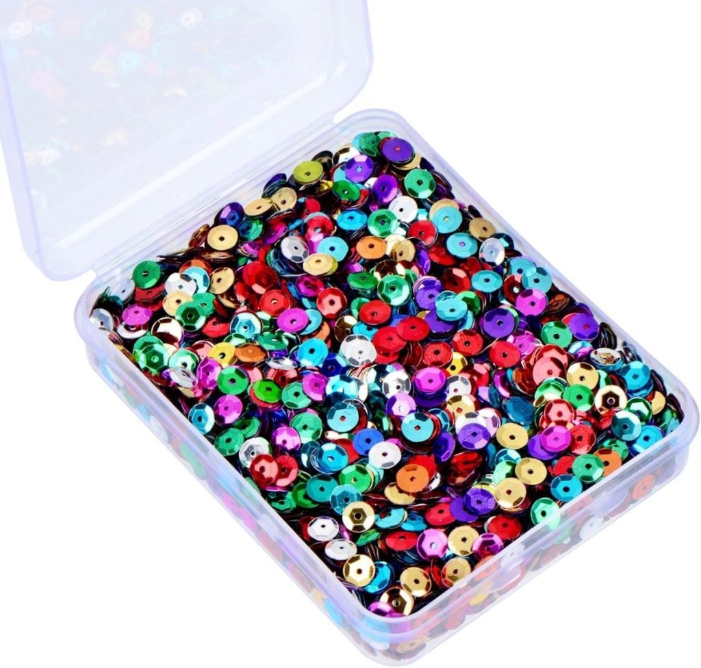 A clear plastic container filled with assorted colorful, round sequins.