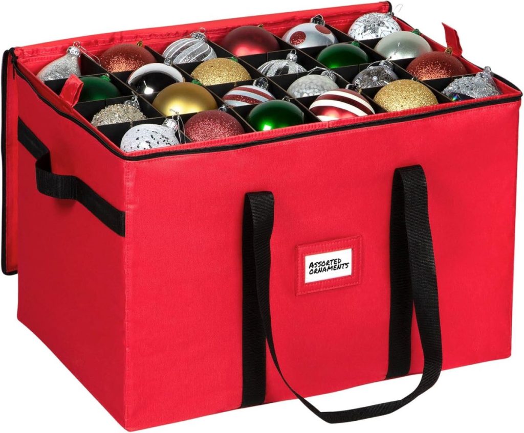 A red storage box with black handles holds several Christmas ornaments organized in individual compartments.