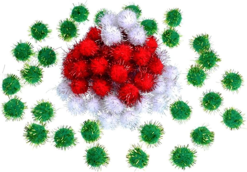 A pile of red and white glitter pom poms surrounded by green glitter pom poms on a white background.
