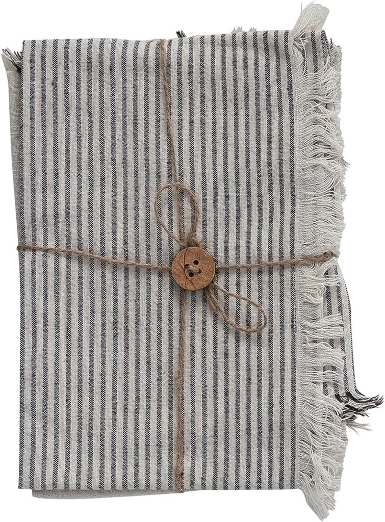 Folded striped fabric with fringed edges, tied with a string and wooden button.