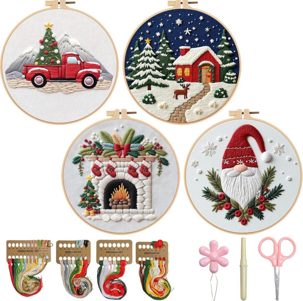 Four embroidered hoop art designs—red truck with tree, snowy house, fireplace, and Santa face—are shown with embroidery threads, needle threaders, scissors, and pen tools.