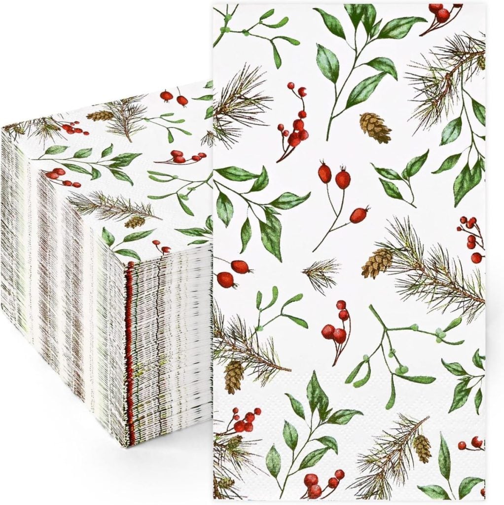 A stack of white paper napkins decorated with a holiday pattern of green leaves, red berries, and pinecones—perfect as a festive hostess gift.