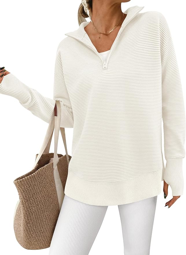 Woman wearing an off-white ribbed quarter-zip sweater, white ribbed pants, and a white top, holding a woven beige tote bag over her shoulder, styled as elegantly as vintage Mercury Glass Ornaments.