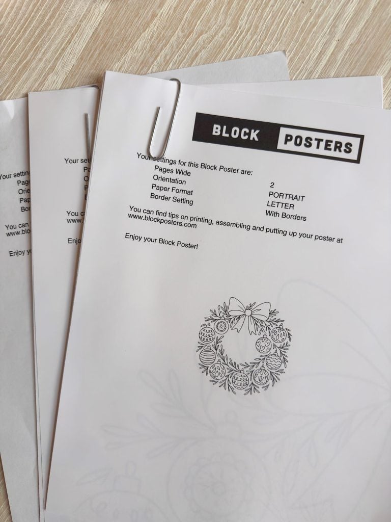 Three printed sheets of paper with the heading “BLOCK POSTERS,” clipped together on a wooden surface, showing poster printing instructions and a decorative floral design.