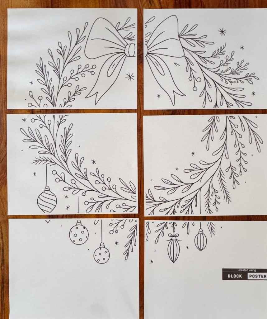 Six sheets of paper arranged together to form a black and white drawing of a holiday wreath with a bow, ornaments, and foliage.
