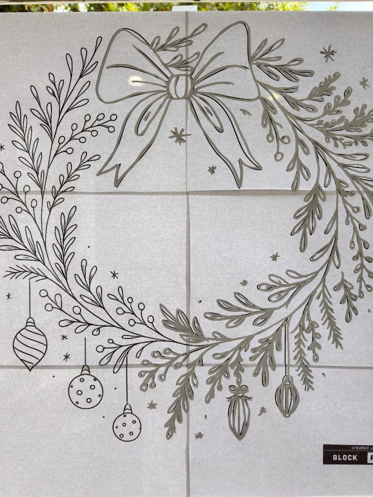 Line drawing of a holiday wreath with a large bow, ornaments, and foliage on a tiled background with some visible trees through the window above.