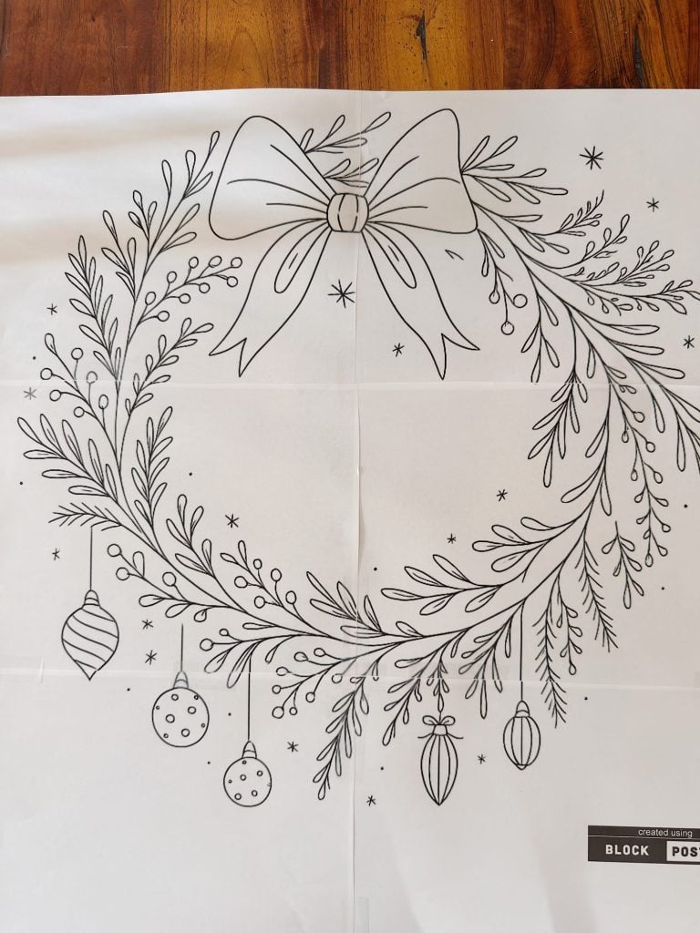 Black and white outline drawing of a holiday wreath with a large bow, hanging ornaments, and sprigs, designed for coloring.