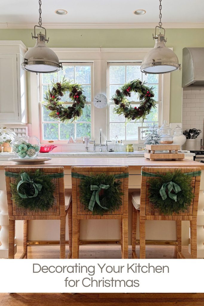 A kitchen decorated for Christmas with wreaths on the windows and chairs, and holiday-themed items displayed on the counter.