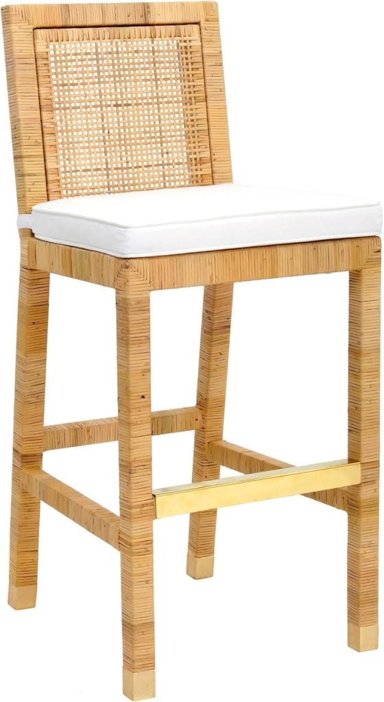 A tall wooden bar stool with a square backrest featuring a woven rattan design and a white cushioned seat; has a metal footrest.