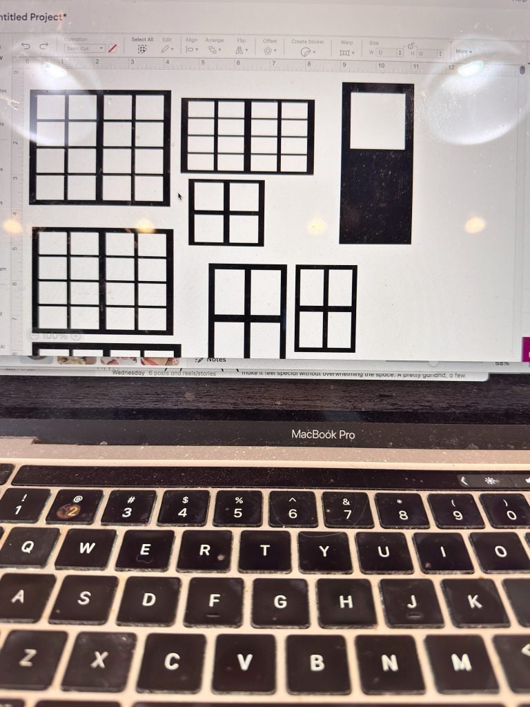 A MacBook Pro displays a screen with a design software open, showing various black rectangular grid window layouts on a white background.