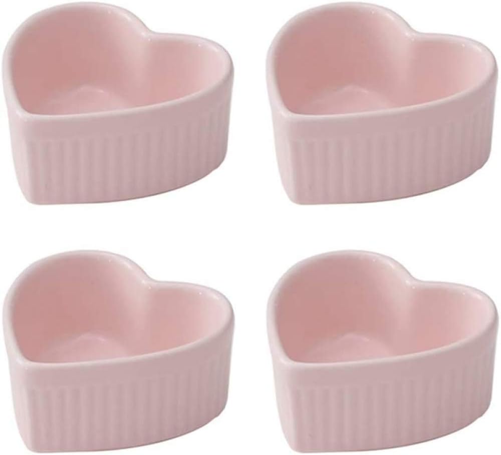 Four pink, heart-shaped ceramic ramekins are arranged in a grid on a white background.