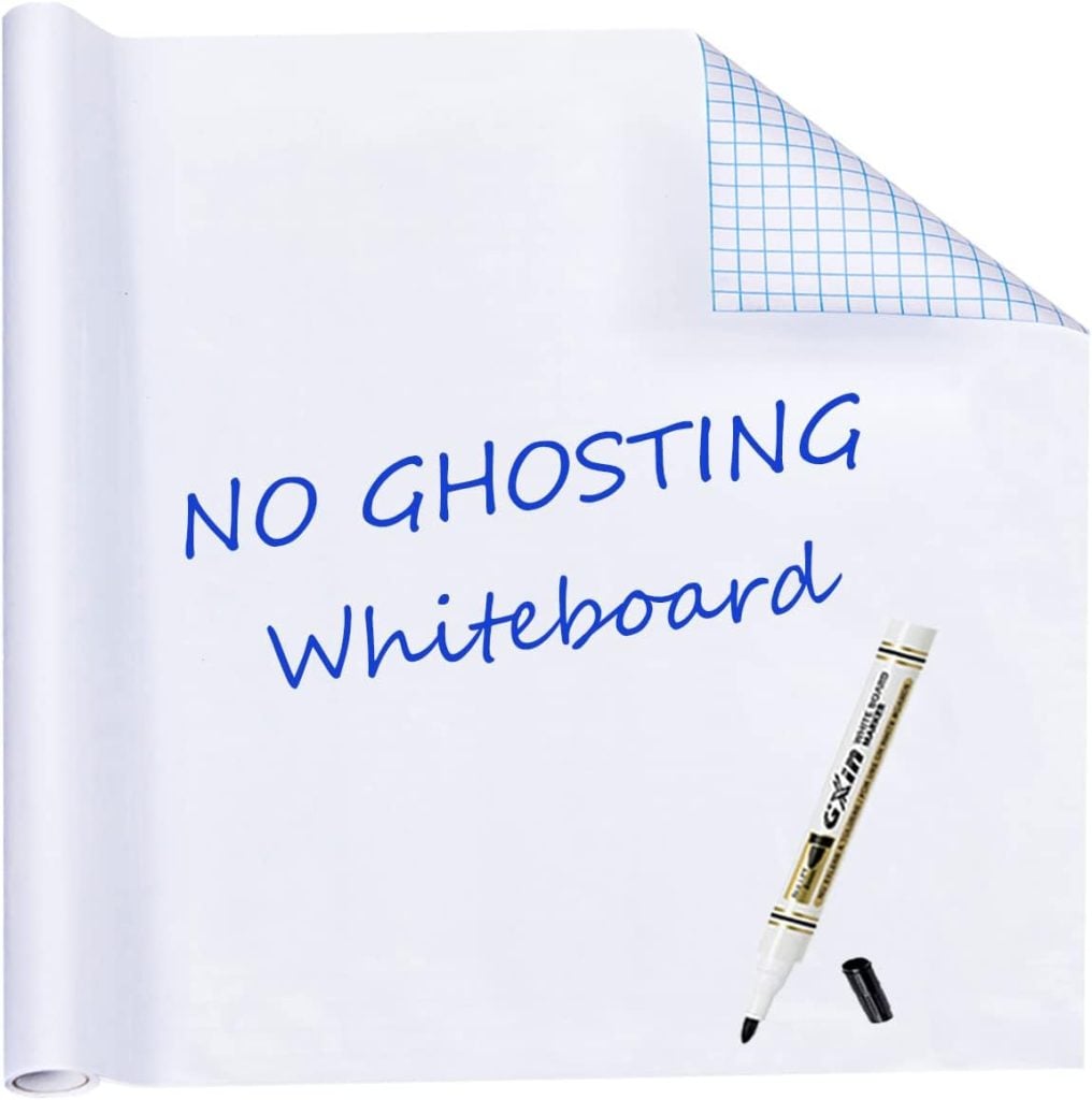 A rolled whiteboard sheet with blue grid backing, labeled "NO GHOSTING Whiteboard," with a black dry erase marker and cap placed on the surface.