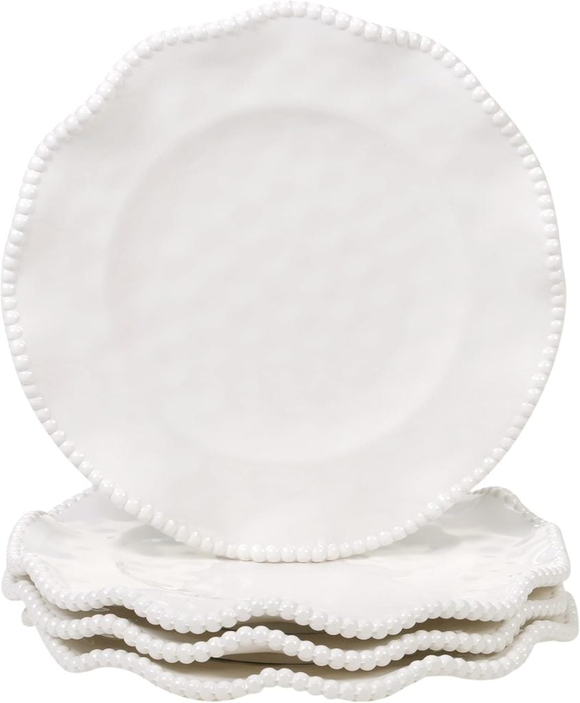 A stack of four white ceramic plates with scalloped edges and a beaded border design&mdash;perfect for elevating your dining experiences among the Things To Do This Year.