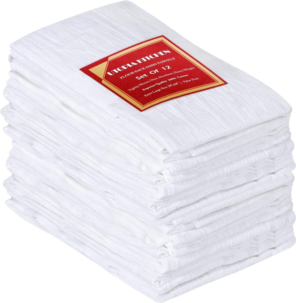 A stack of twelve folded white kitchen towels with a red label on top showing the brand and quantity.