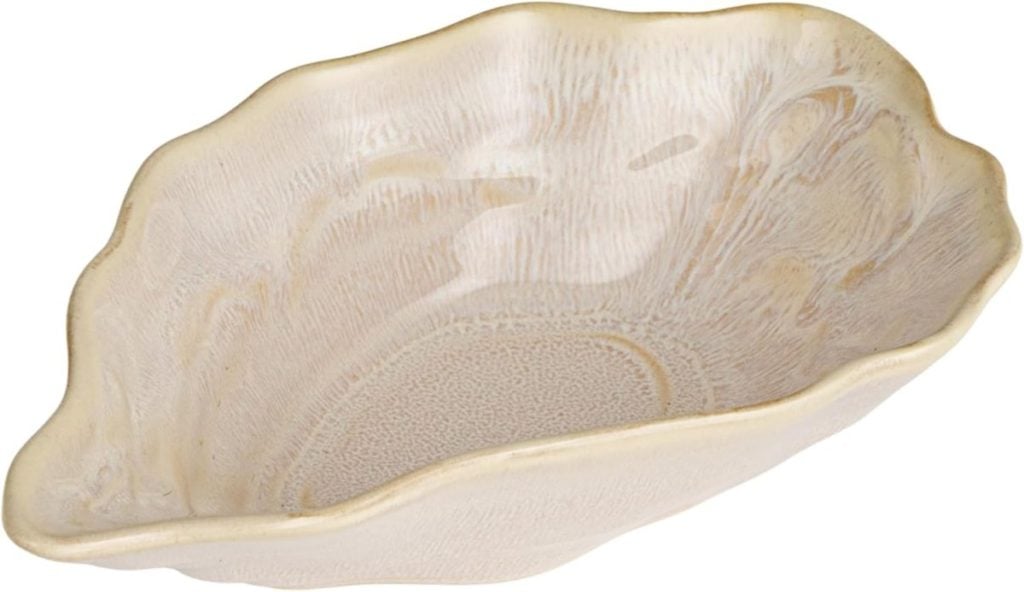 Beige ceramic bowl with a wavy, irregular edge and a textured surface, resembling a shell.