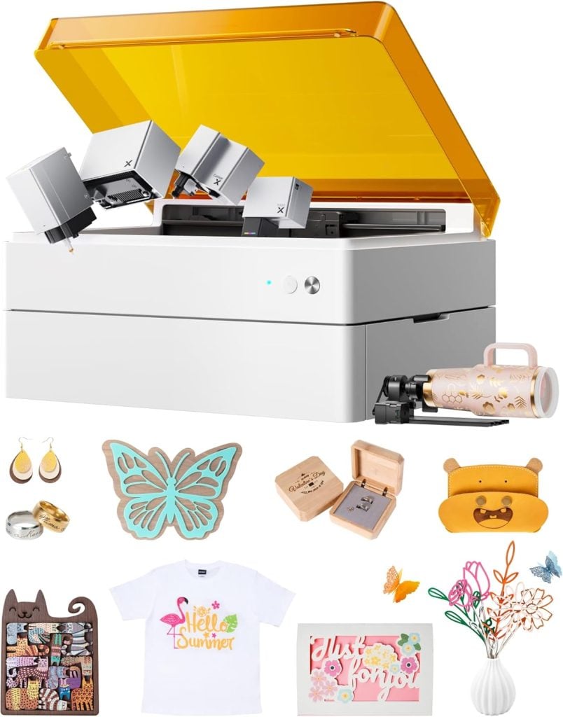 A white and orange desktop cutting and engraving machine is shown with various completed craft projects, including jewelry, boxes, a T-shirt, cards, and decorative items.