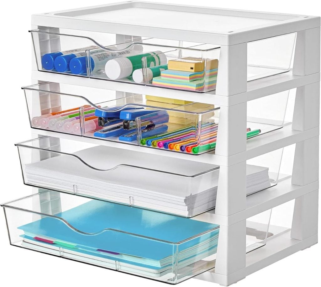 A four-drawer organizer holds markers, glue sticks, sticky notes, pens, highlighters, stapler, clips, paper, and folders, neatly arranged in transparent drawers.