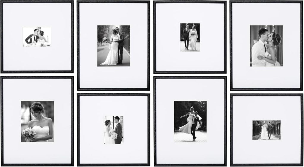A gallery wall display of eight black picture frames, each with a black-and-white wedding photo, arranged in two rows of four on a white background.
